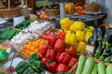 Group of various fresh colourful vegetables lies on market stall. Soft focus. Copy space for your text. Food business theme.