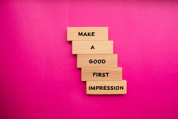 Make a good first impression words written on wooden blocks with pink background. Conceptual...