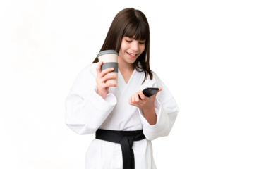 Little Caucasian girl doing karate over isolated background holding coffee to take away and a mobile