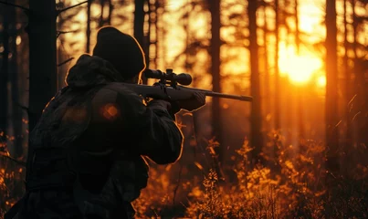 Foto op Aluminium Hunter in holding rifle and shooting at evening forest. © Filip