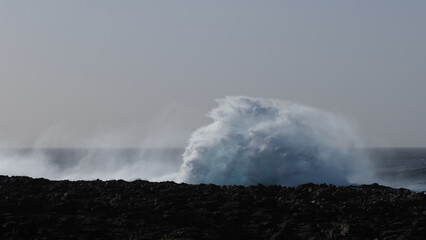 Fototapeta na wymiar Large breaking waves and ocean view in Las Palmas, Canary islands, Spain