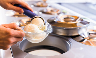 Ball of vanilla ice cream in ice cream razor in cafe