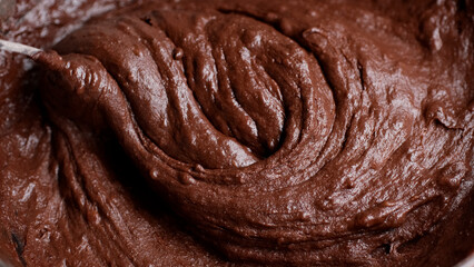 Chef stirring chocolate dough before cooking dessert