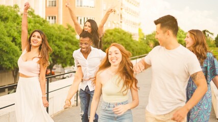 Friends smiling while running playfully in the street