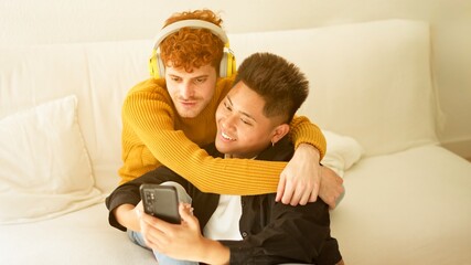 Gay couple listening to music together on the sofa