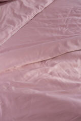 wrinkled pink cotton bed linen blanket