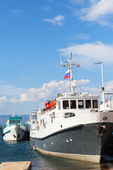 Baikal Lake in summer. Ships and yachts at the pier on the shores of the Small Sea on a sunny summer day. The village of Sakhyurta is traditionally the starting point for water travel around the lake