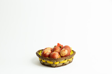 Red easter eggs decorated with leaves pattern placed in a heart shaped easter basket isolated on a white background. copy space