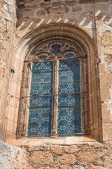 Fototapeta na wymiar exterior of gothic window with stained glass on a stone facade