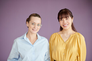 Studio portrait of female coworkers smiling at camera