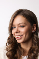 Naklejka premium Beautiful young girl with fresh healthy skin. Woman advertise ear-rings. White background. Earrings closeup. Blond european woman with long hair with big lips, pretty smile. Cosmetology, scincare. 