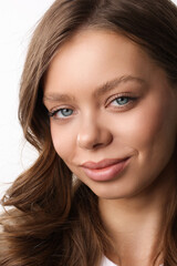 Obraz premium Beautiful young girl with fresh healthy skin. Woman advertise ear-rings. White background. Earrings closeup. Blond european woman with long hair with big lips, pretty smile. Cosmetology, scincare. 