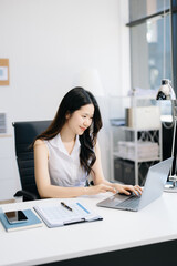  Asian Businesswoman Analyzing Finance on Tablet and Laptop at modern Office Desk tax, report, accounting, statistics