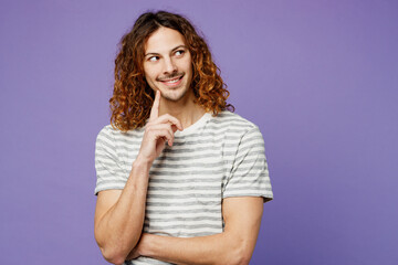 Young happy man wears grey striped t-shirt casual clothes put hand prop up on chin, lost in thought...