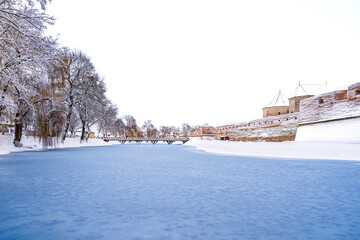 Medieval Fagaras Fortress covered in snow on the shores of the frozen lake; Fagaras citadel in Fagaras, Brasov county, Transylvania, Romania - 745152472
