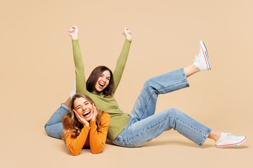 Full body happy young friends two women wear orange green shirt casual clothes together sit lay...