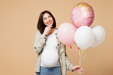 Young happy minded pregnant woman future mom wear grey shirt with belly stomach tummy with baby hold bunch of inflated balloons isolated on plain beige background. Maternity family pregnancy concept.