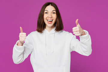 Young cheerful satisfied smiling happy Caucasian woman she wears light hoody casual clothes looking camera show thumb up isolated on plain purple color background studio portrait. Lifestyle concept.