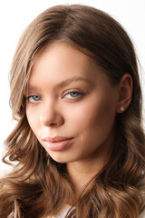 Fototapeta premium Beautiful young girl with fresh healthy skin. Woman advertise ear-rings. White background. Earrings closeup. Blond european woman with long hair with big lips, pretty smile. Cosmetology, scincare