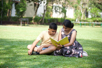 Happy mother and her teenage son spending time together with book 