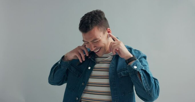 Man, dancing with earpods and smartphone for music, fun and energy in studio with happiness on grey background. Mobile app for entertainment, technology for moving with rhythm and listening to radio