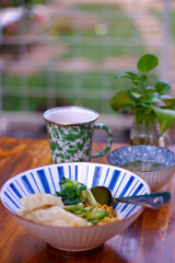 A bowl of noodles on the table.  mie ayam 