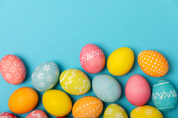 Easter eggs on a bright blue background. Easter celebration concept. Colorful easter handmade decorated Easter eggs. Place for text. Copy space.