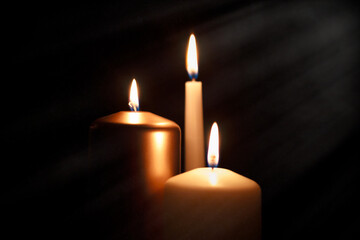 Funeral symbol with burning candle in darkness