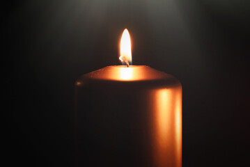 Funeral symbol with burning candle in darkness