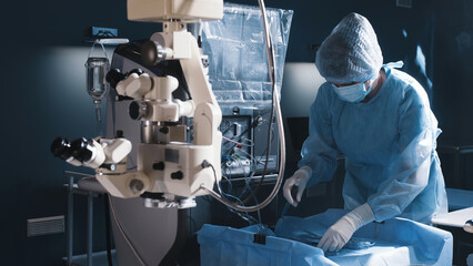 In a modern ophthalmology operating room, a patient is prepared for surgery. A group of medical...