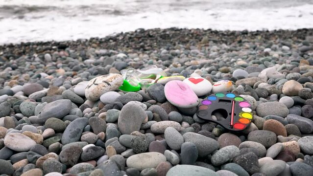 Happiness concept. Pebble seashore made of multi-colored pebbles. Natural background. Sea pebble texture