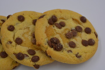 Sweets, delicious, large cookies with small pieces of milk chocolate arranged on a white background.