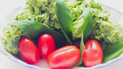 Allium ursinum wild bear garlic butter in a bowl with red tomatoes