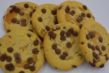 Sweets, delicious, large cookies with small pieces of milk chocolate arranged on a white background.