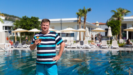 A male tourist from  USA on vacation in Turkey drinks a cocktail.