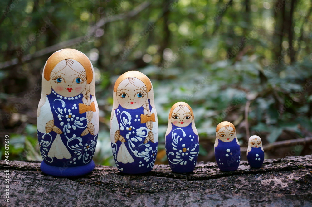 Wall mural Figurines of beautiful dolls in the forest. Matryoshka dolls.