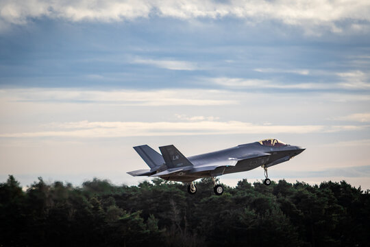 F35 coming into land at RAF Lakenheath with landing gear down, images shows the fighter jet coming into land with a cloudy sky and trees