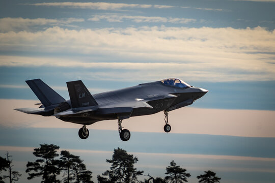 F35 coming into land at RAF Lakenheath with landing gear down during sunset, image shows a colourful sunset with clouds