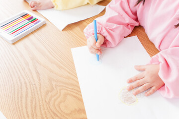 お絵かきをする子どもたちと保育士