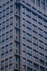 Fototapeta premium Exterior of modern skyscraper object. Architectural detail of a skyscraper, close-up on the windows. Real estate, residential apartments and offices. Office building architecture.