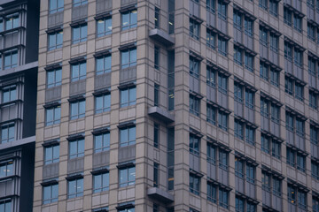 Obraz premium Exterior of modern skyscraper object. Architectural detail of a skyscraper, close-up on the windows. Real estate, residential apartments and offices. Office building architecture.