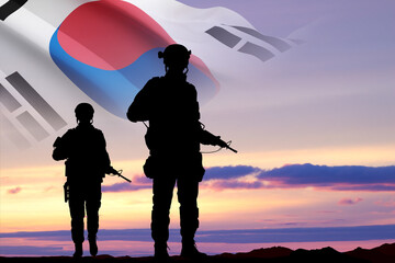 Fototapeta na wymiar Silhouettes of a soldiers with South Korea flag against the sunset