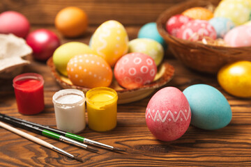 Easter egg painting at the kitchen table.Happy Easter celebration concept.Colorful Easter eggs with different patterns.Paints,decorations for coloring eggs for holiday.Creative background.Copy space
