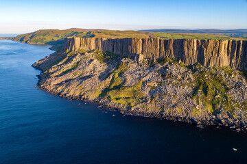 Fair Head or Benmore big cliff and headland at the Atlantic coast of County Antrim, Northern Ireland, UK,  in sunset light.