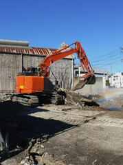 解体現場で作業中の重機。
ビル解体後、コンクリート片を処理中。
日本の工事現場の風景。