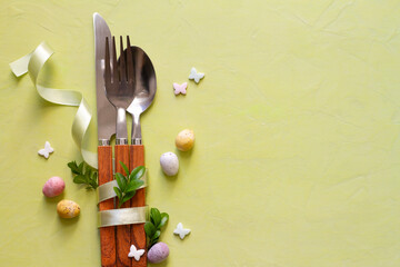 Easter decoration with cutlery on pastel background, copy space