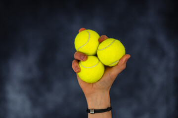 Drei Tennisbälle in einer Hand
