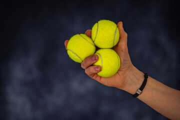 Drei Tennisbälle in einer Hand