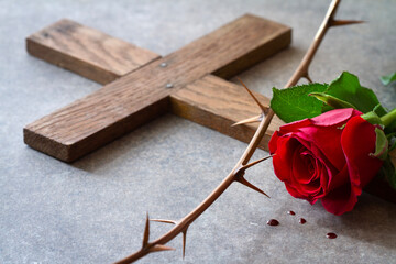 Red rose, wooden cross and thorns. Passion of Christ symbol, concept