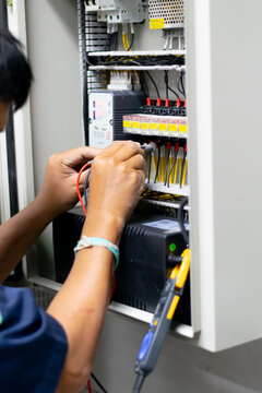 Electrician work tester measuring voltage and current of power electric line in electrical cabinet control, Professional man uses tool commissioning test or checking circuit for protection system.